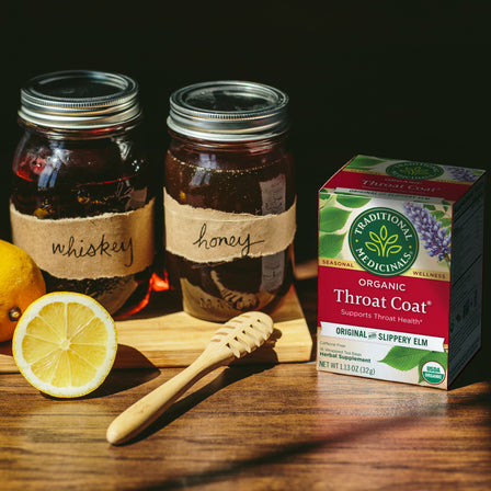 Throat Coat® Tea with jar of honey and whiskey and lemon next to it